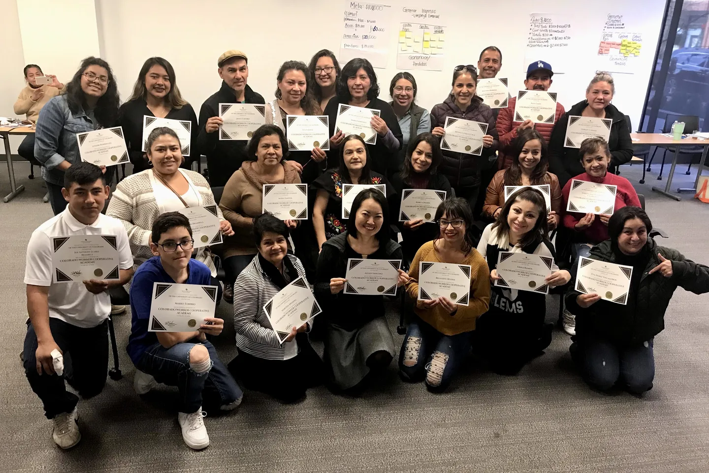 Participants holding certificates at a Colorado worker cooperative academy gathering